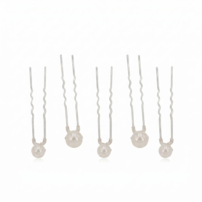 Set of five silver pearl hairpins with ivory pearls and polished silver finish, arranged flat lay, ideal for elegant hairstyling.